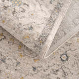 Close-up of the Annie Cream Textured Rug. Features a farmhouse style pattern in cream, gray, and gold tones. Fold