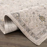 Close up of the Annie Cream Textured Rug showing its traditional pattern and soft, neutral colors. Fold