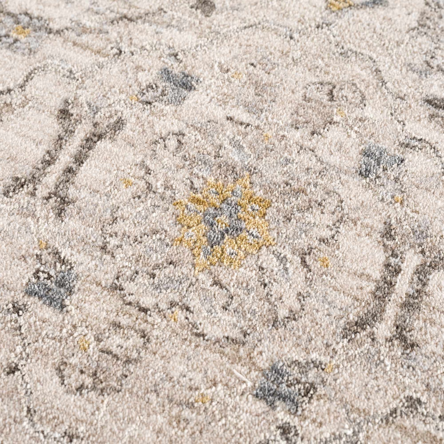 Close-up of the Annie Cream Textured Rug with floral design in cream, gray and gold tones. Texture