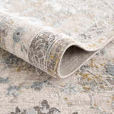 Close-up of the textured Alroy Rug with Fringes, showing gray, brown, and natural tones in a traditional pattern. Fold
