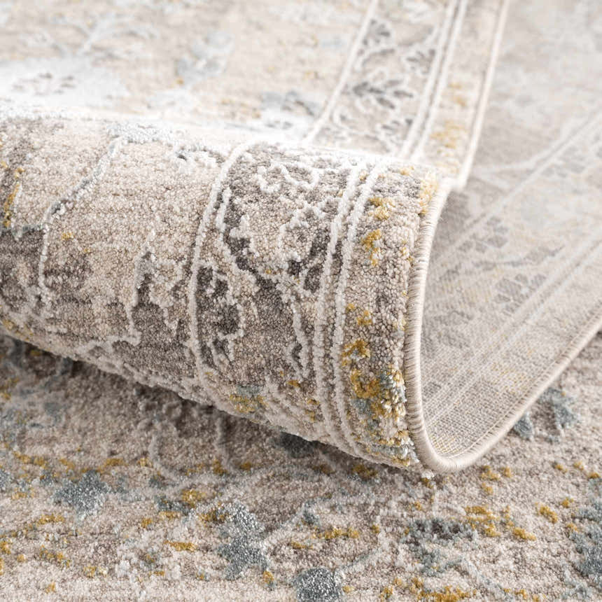 Close-up of the Alroy Textured Rug, showcasing its gray, brown, and gold tones and intricate traditional pattern. Fold