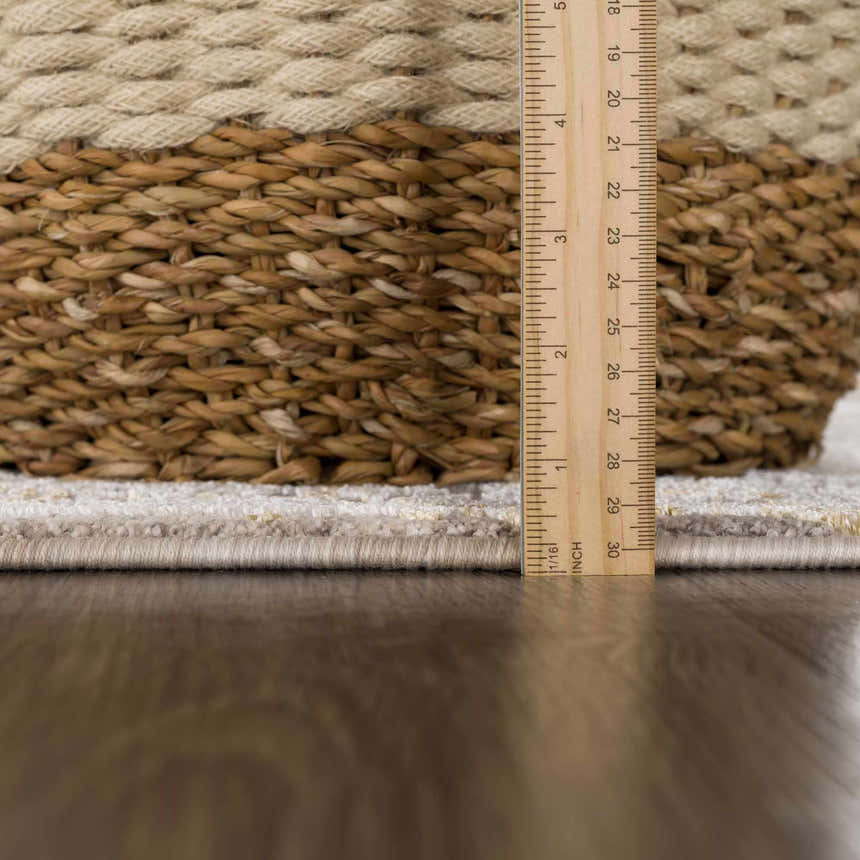 Close up of the Alroy Textured Rug showing the pile height with a ruler and a basket. Pile