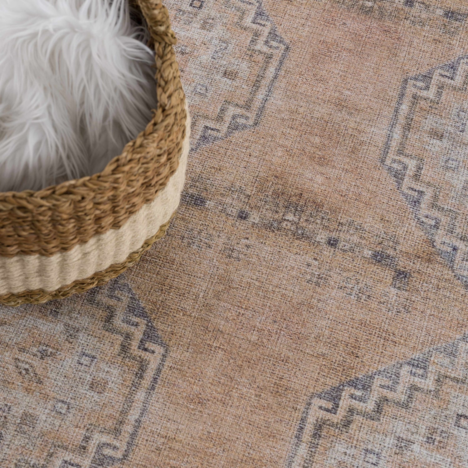 Close-up of the Carrabelle Peach Washable Area Rug, a traditional design in peach, ivory and navy with a basket detail. Styleshot