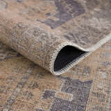 Close-up of the Carrabelle Peach Washable Area Rug showing its traditional pattern, chenille texture, and bound edge. Fold