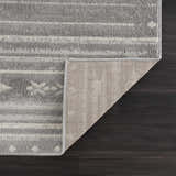 Close-up of Tigri Aztec Ivory & Gray rug showing the gray, ivory pattern, texture, and rug backing on dark wood floor. Fold