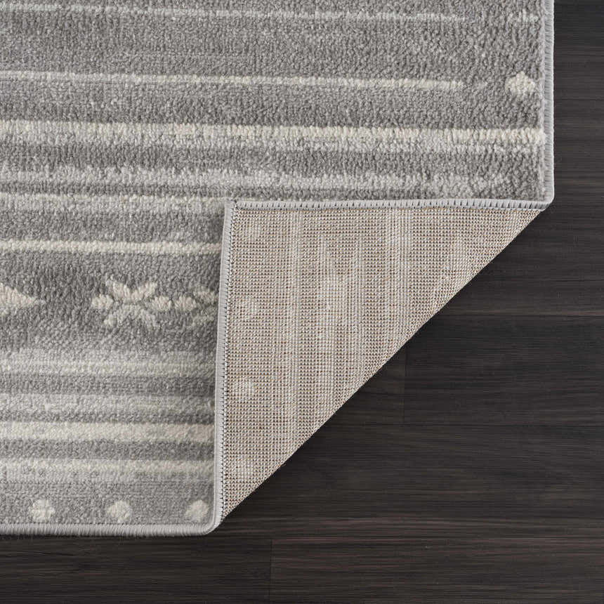 Close-up of Tigri Aztec Ivory & Gray rug showing the gray, ivory pattern, texture, and rug backing on dark wood floor. Fold
