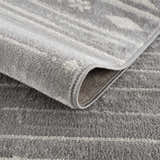 Close-up of the Tigri Aztec Ivory & Gray area rug showing the texture, pattern, and edge binding. Fold