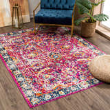 Living room scene with a vibrant New Vick Area Rug, blue chair, and monstera plant. Roomscene-Rectangle