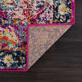 Close-up of New Vick Area Rug. Farmhouse style with pink trim, navy, gold, orange, and turquoise floral pattern. Fold