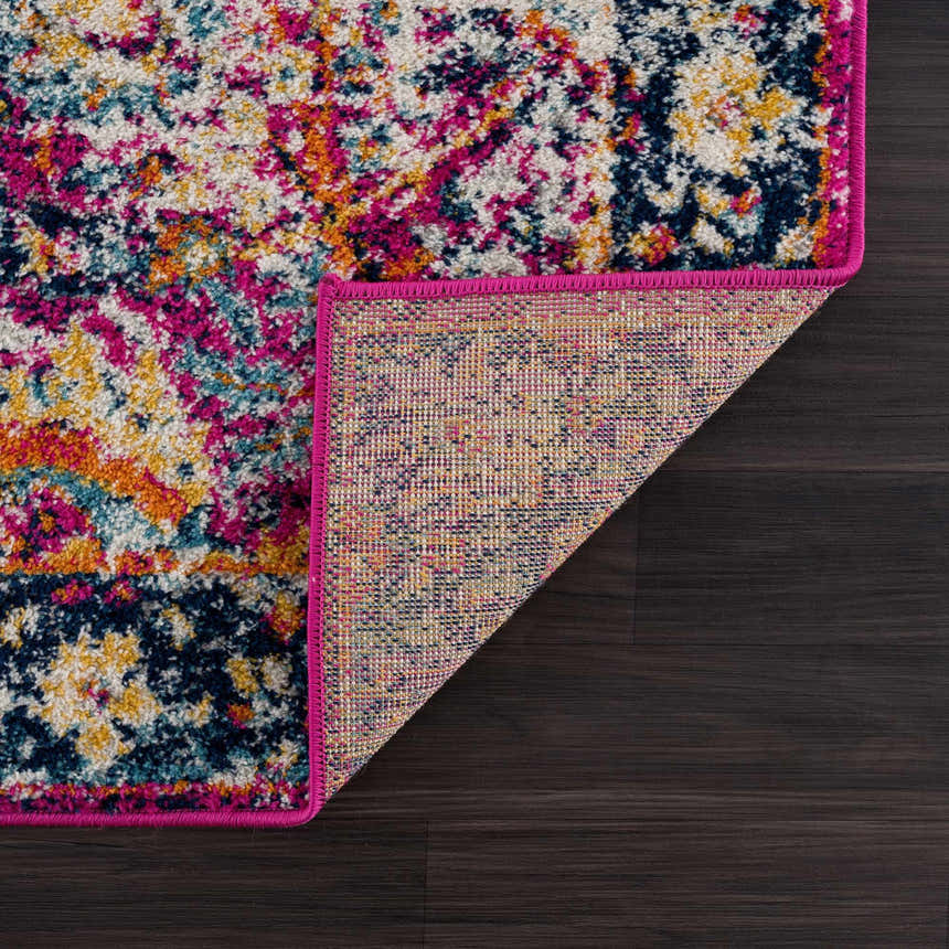 Close-up of New Vick Area Rug. Farmhouse style with pink trim, navy, gold, orange, and turquoise floral pattern. Fold