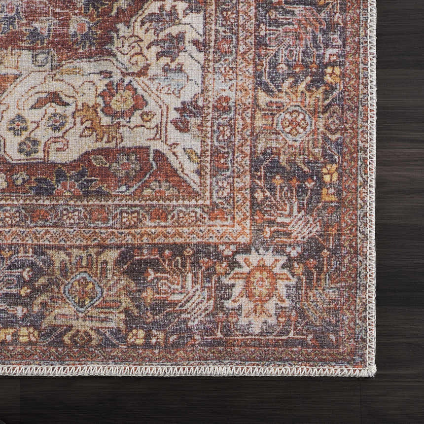 Close-up of the Rust Elki Vintage Medallion Washable Area Rug, showing rust, blue, and off-white Persian-style pattern. Swatch