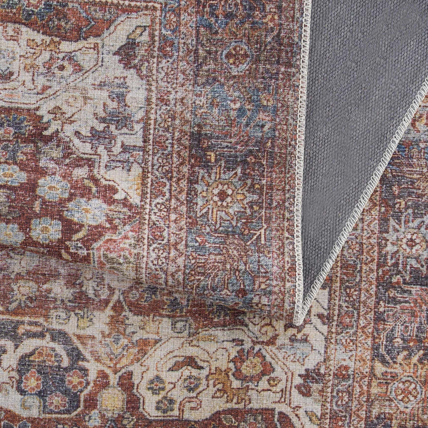 Close-up of the Rust Elki Vintage Medallion Washable Area Rug, showcasing its rust, blue, and off-white Persian-style pattern. Fold