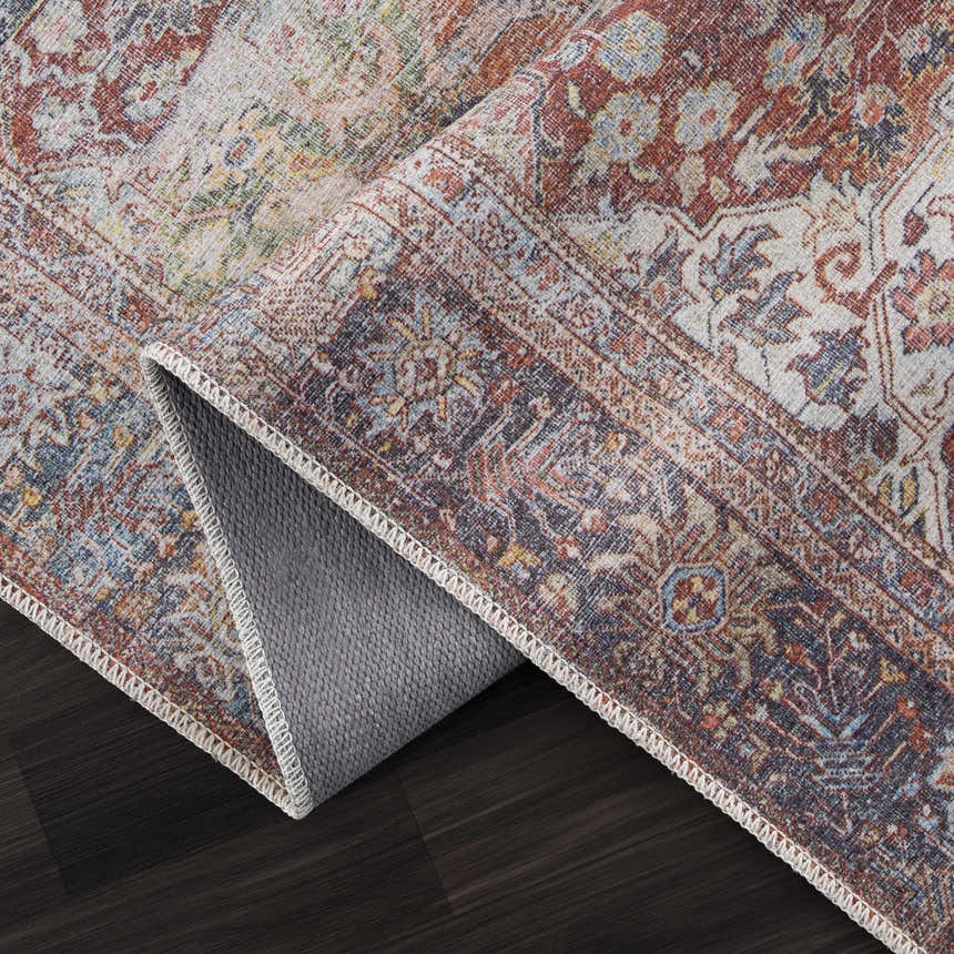 Close-up of the Rust Elki Vintage Medallion Washable Area Rug, showing its rust, blue, and off-white Persian-style design. Fold