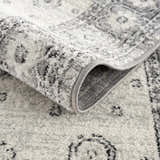 Close-up of the Marash 4605 Gray Area Carpet showing its traditional pattern, soft texture, and gray, ivory, and silver gray colors. Fold