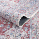 Close-up of the Rust Goma Vintage Area Rug showing its blush, cream, and blue traditional floral pattern and machine-woven texture. Fold