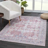Living room scene with Rust Goma Vintage Area Rug, cream chair, and natural light. The rug adds a touch of bohemian style. Roomscene-Rectangle