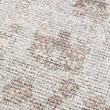 Close-up of Niran Area Rug showing a neutral, vintage pattern. Machine woven texture in beige and brown tones. Texture