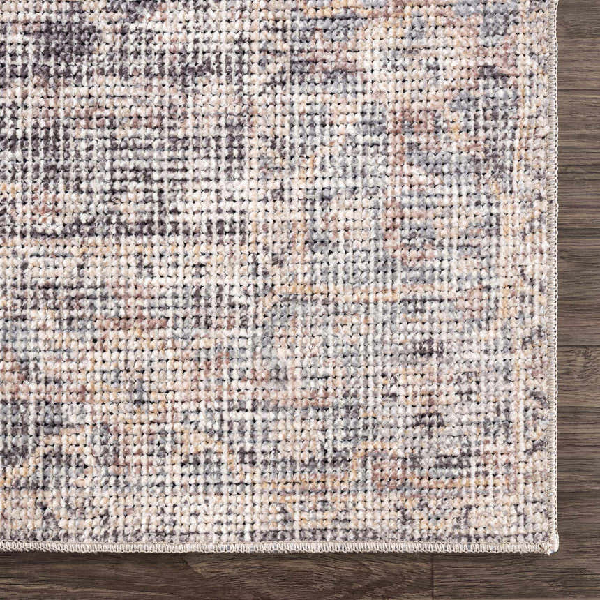 Close-up of the Nyota Area Rug. Traditional vintage style with gray, beige, and brown tones. Machine-woven texture. Corner