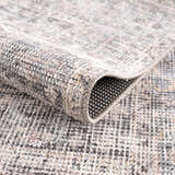 Close-up of the Nyota Area Rug showing its vintage traditional design, soft texture, and neutral gray, beige, and brown tones. Fold