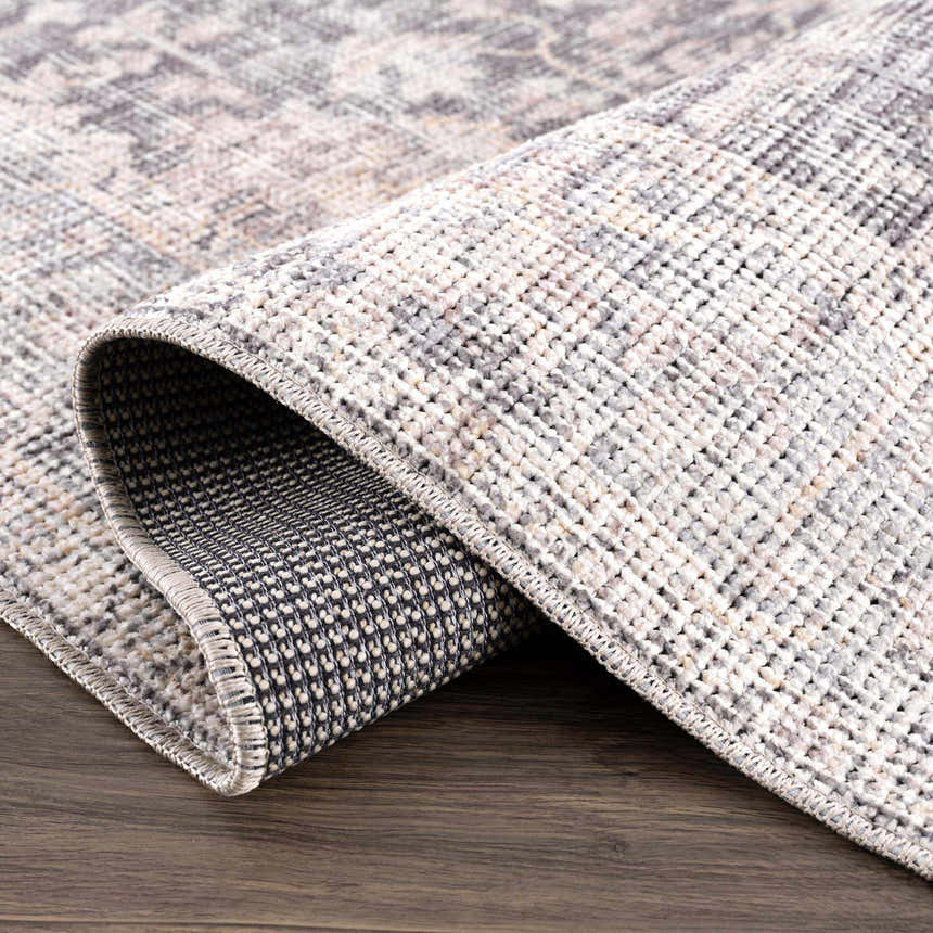 Close up of rolled Nyota Area Rug showing traditional vintage pattern and texture. Fold