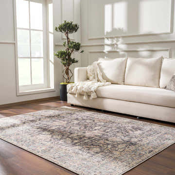 Living room scene with a vintage Nyota Area Rug, beige sofa, wood floors, and natural light. Roomscene-Rectangle