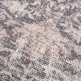 Close-up of the Nyota Area Rug. Machine-woven polyester rug with a traditional vintage design in gray, beige, and white. Texture