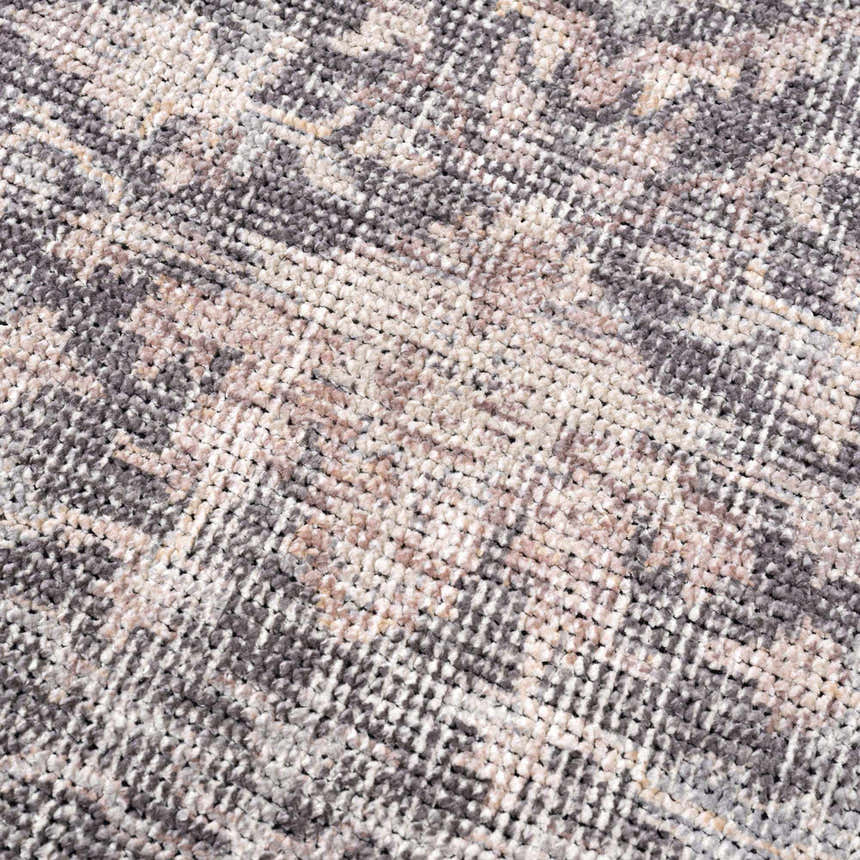 Close-up of the Nyota Area Rug. Machine-woven polyester rug with a traditional vintage design in gray, beige, and white. Texture
