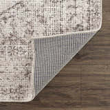 Close-up of Mortye Cream & Brown Medallion Area Rug showing texture, backing, and medallion pattern on a dark wood floor. Fold