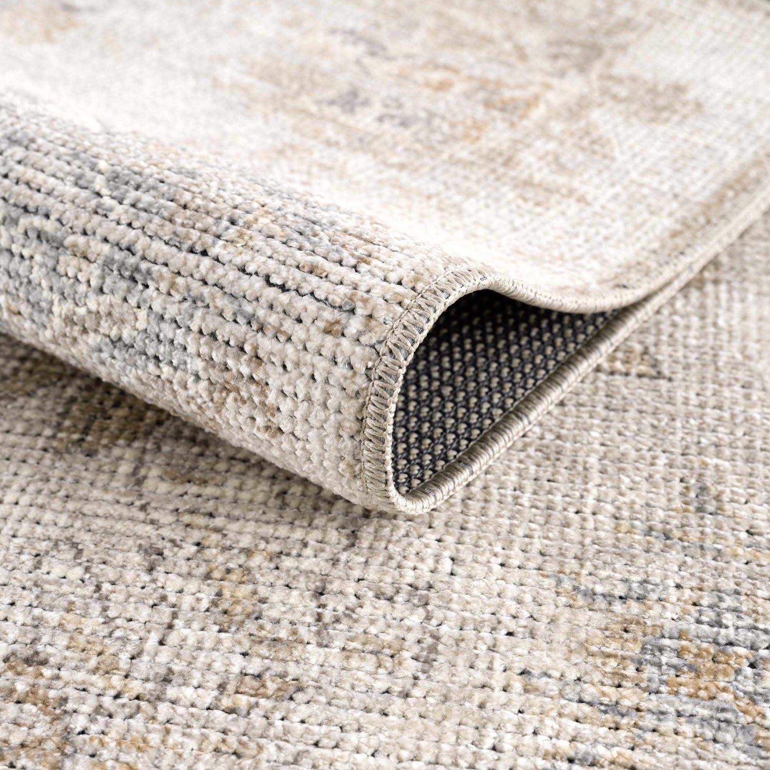 Close up of the Melor Area Rug showing its texture, weave, and backing. Fold