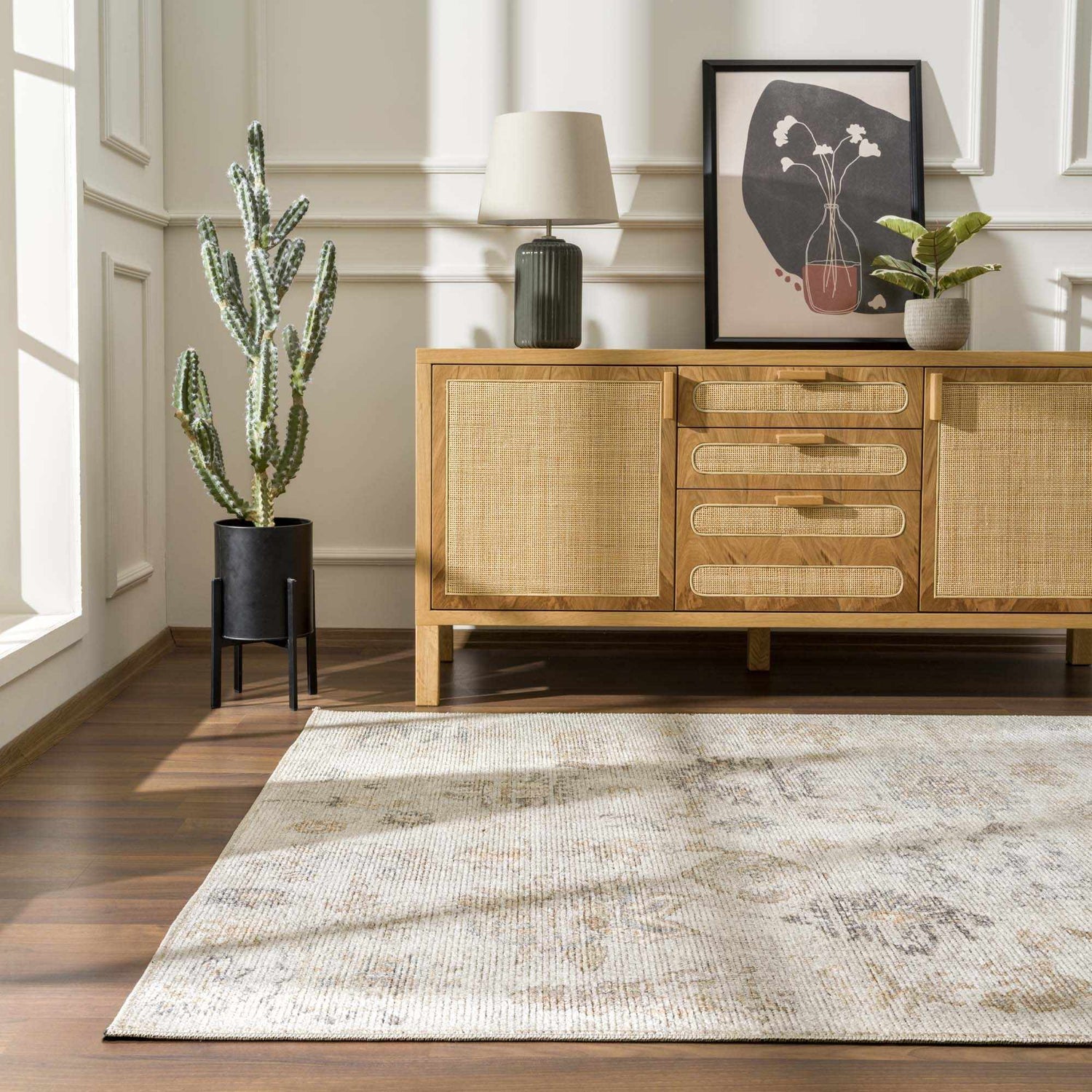 Living room scene with a light beige Melor Area Rug, wood floors, and a cane-front cabinet with decor. Roomscene-Rectangle