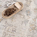 Close-up of the Melor Area Rug showcasing its traditional vintage pattern in cream, gray, and gold hues. Styleshot