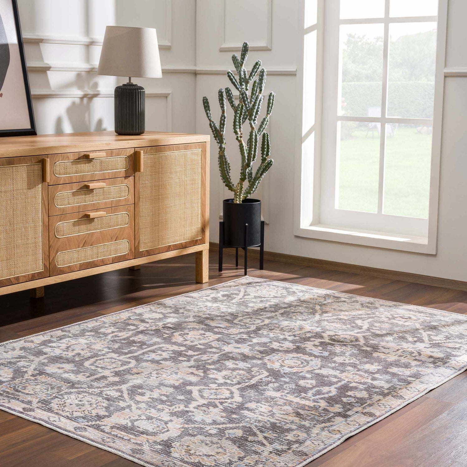 Living room scene with a traditional Okoth Area Rug, wood floors, and a light wood cabinet. Roomscene-Rectangle
