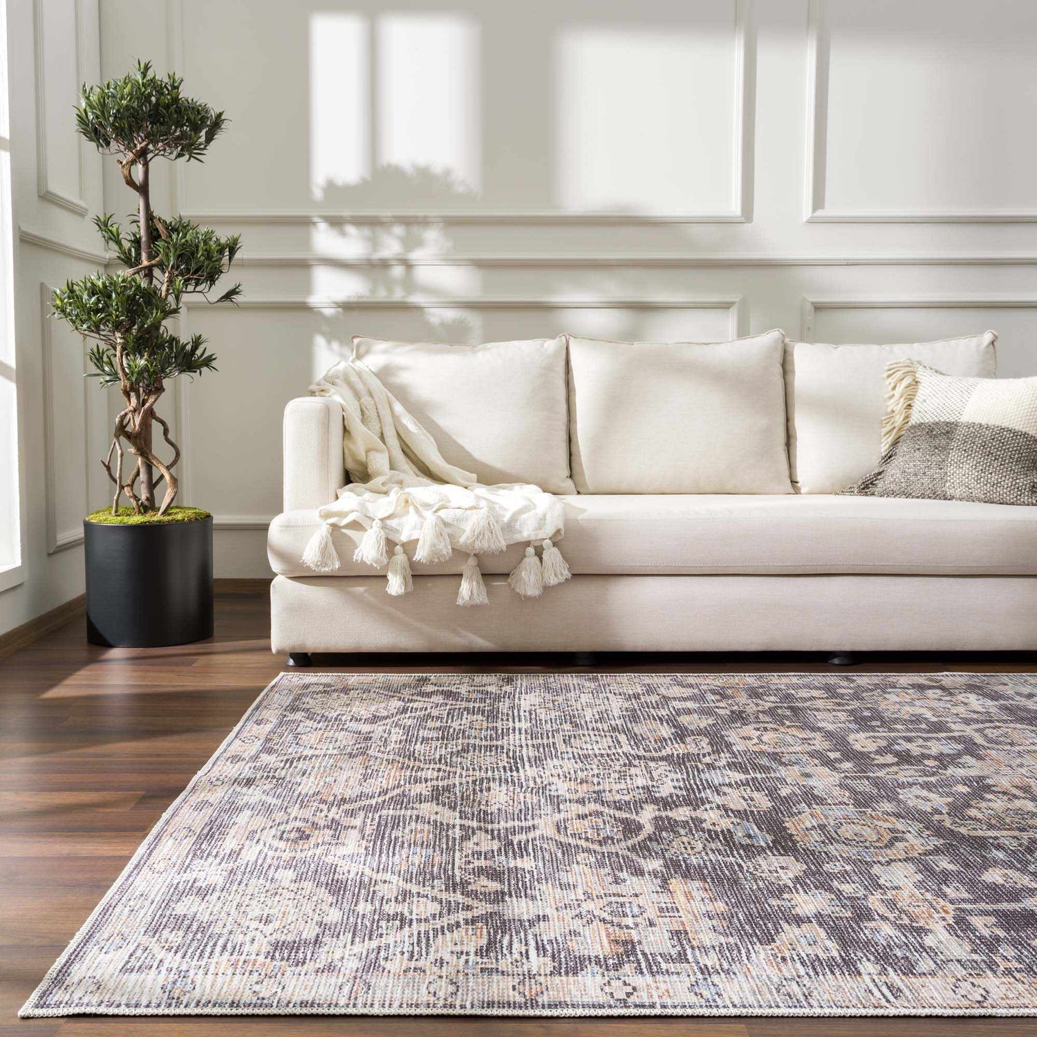 Living room scene with a neutral sofa and the traditional Okoth Area Rug in gray, brown and beige tones. Roomscene-Rectangle