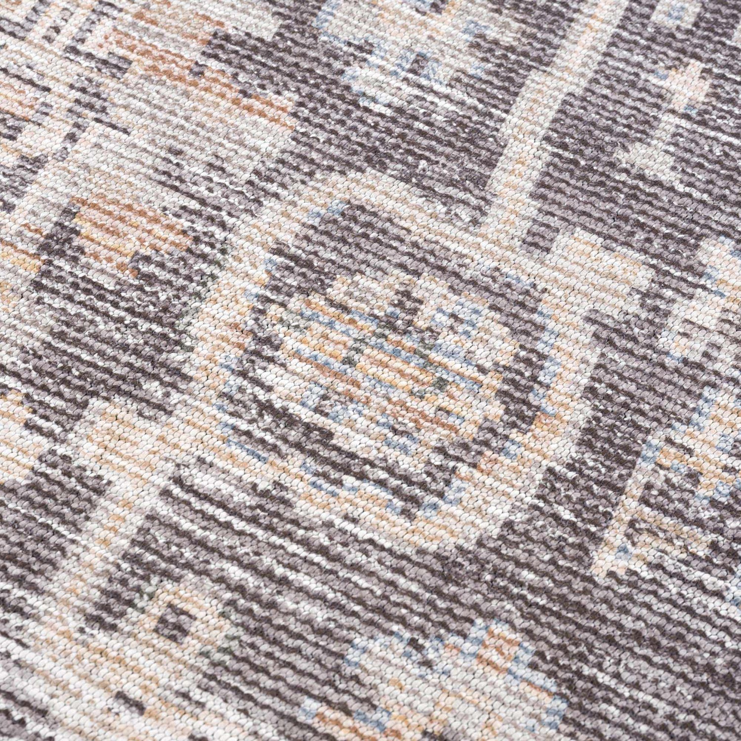 Close-up of the Okoth Area Rug showing a traditional pattern in gray, tan, and blue hues. Texture
