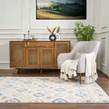 Living room scene with Eivin Pink & Blue Area Rug, wood cabinet, gray chair, and Tuscan landscape art. Roomscene-Rectangle