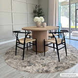 Dining room with round wood table and black chairs on a round Morinville Teal Floral Rug. Roomscene-Round