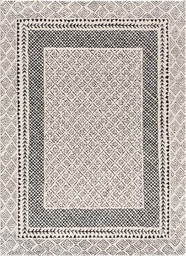 Close-up of the Julio Area Rug, a beige rug with black geometric diamond and floral patterns. Bohemian style. Design-Rectangle-537