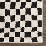 Close-up of the plush Lajos Black & White Checkered Rug. Features a soft, textured checkerboard pattern in black and ivory. Swatch