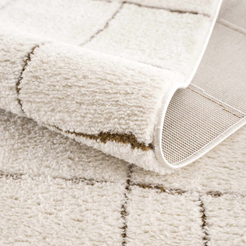 Close-up of the Beige Keanu Area Rug showing geometric design, soft texture, and woven backing. Fold