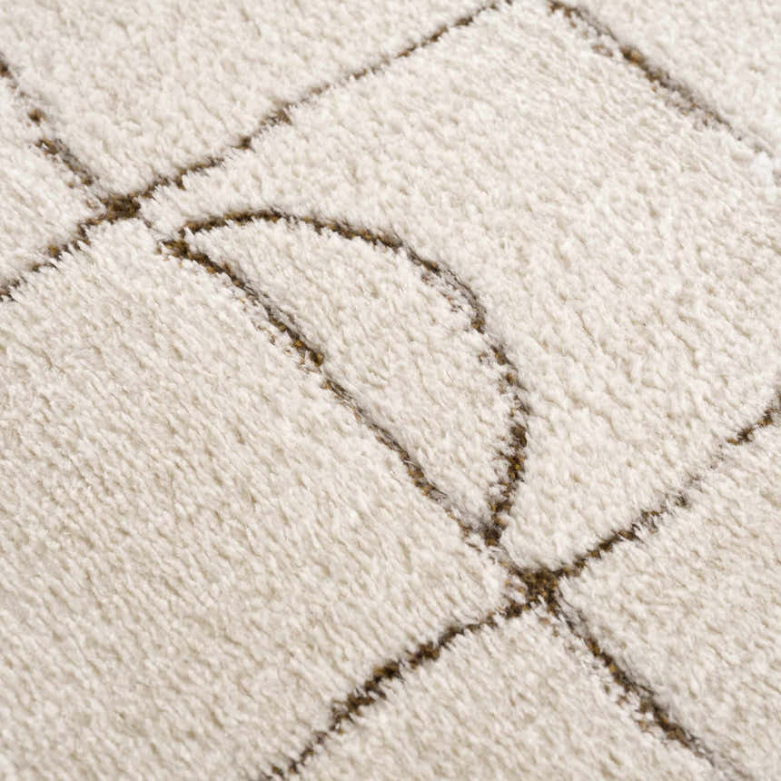 Close-up of the plush, off-white Keanu Area Rug with a brown geometric line pattern. Texture
