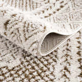 Close up of the Julio Scandi Boho Area Rug, showing its beige and brown textured pattern and machine-woven construction. Fold