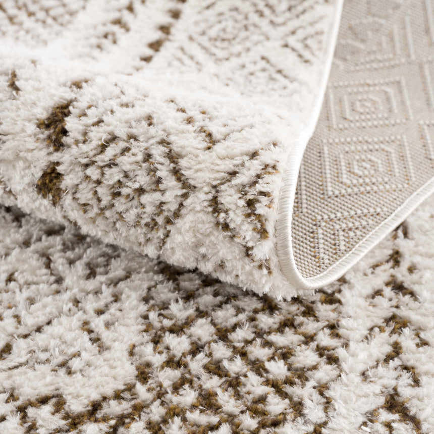 Close-up of the Julio Scandi Boho Area Rug in brown, beige and ivory. Features a textured, geometric pattern and woven backing. Fold