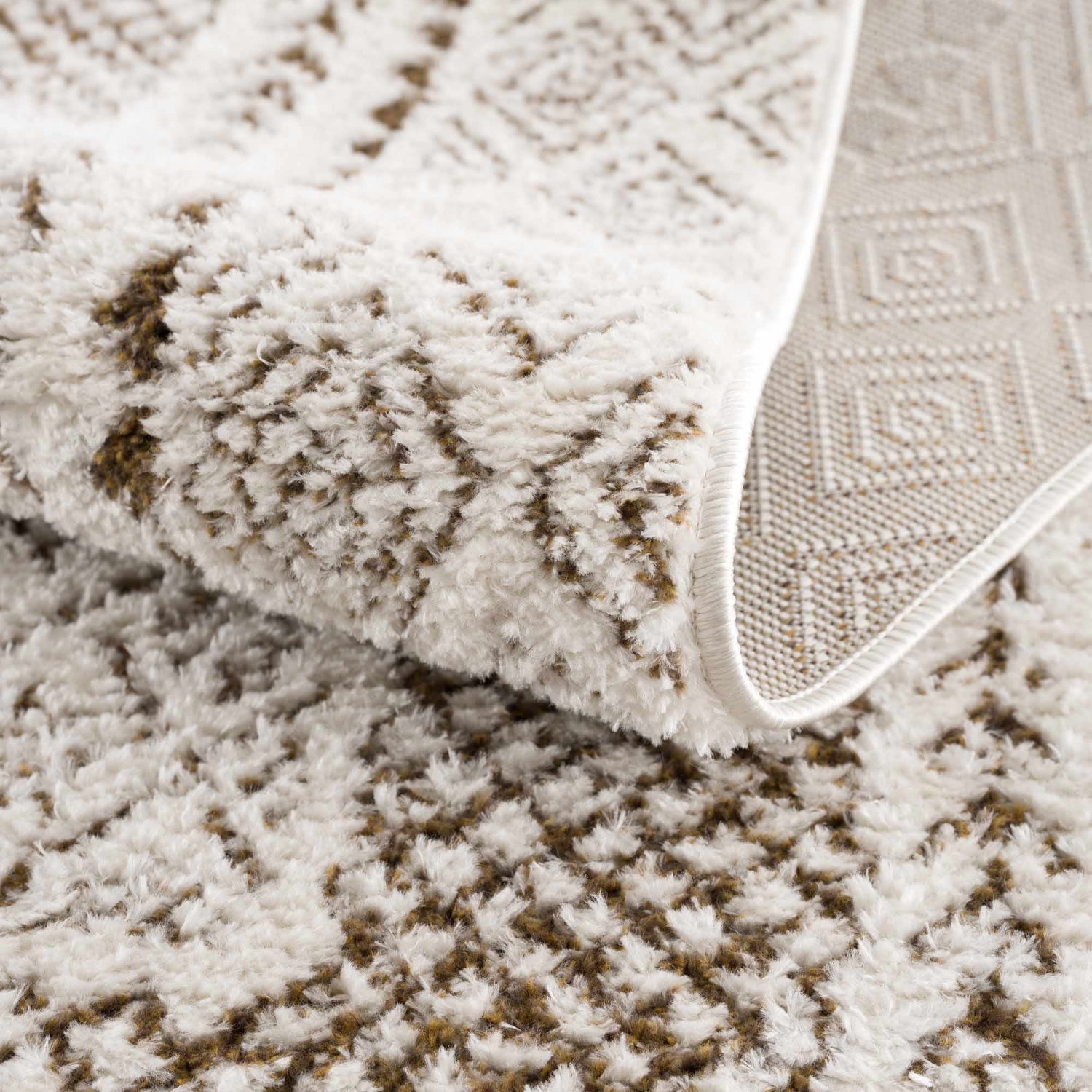 Close-up of the Julio Scandi Boho Area Rug in brown, beige and ivory. Features a textured, geometric pattern and woven backing. Fold