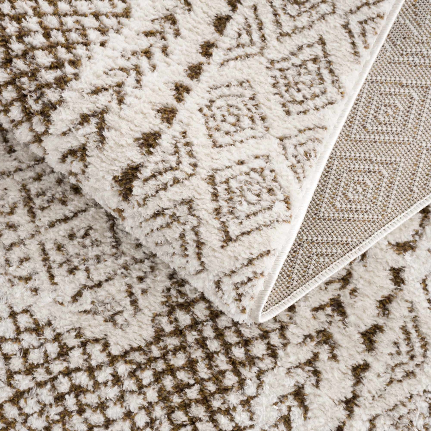 Close-up of Julio Scandi Boho Area Rug. Brown geometric pattern on beige, bone, and ivory polyester rug. Machine woven texture. Fold