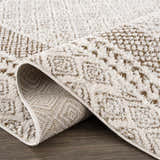 Close-up of the Julio Scandi Boho Area Rug. Beige and brown geometric pattern, soft texture, machine woven. Fold