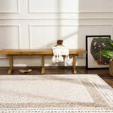 Entryway with a light wood bench and the beige Julio Scandi Boho Area Rug on a dark wood floor. Roomscene-Rectangle