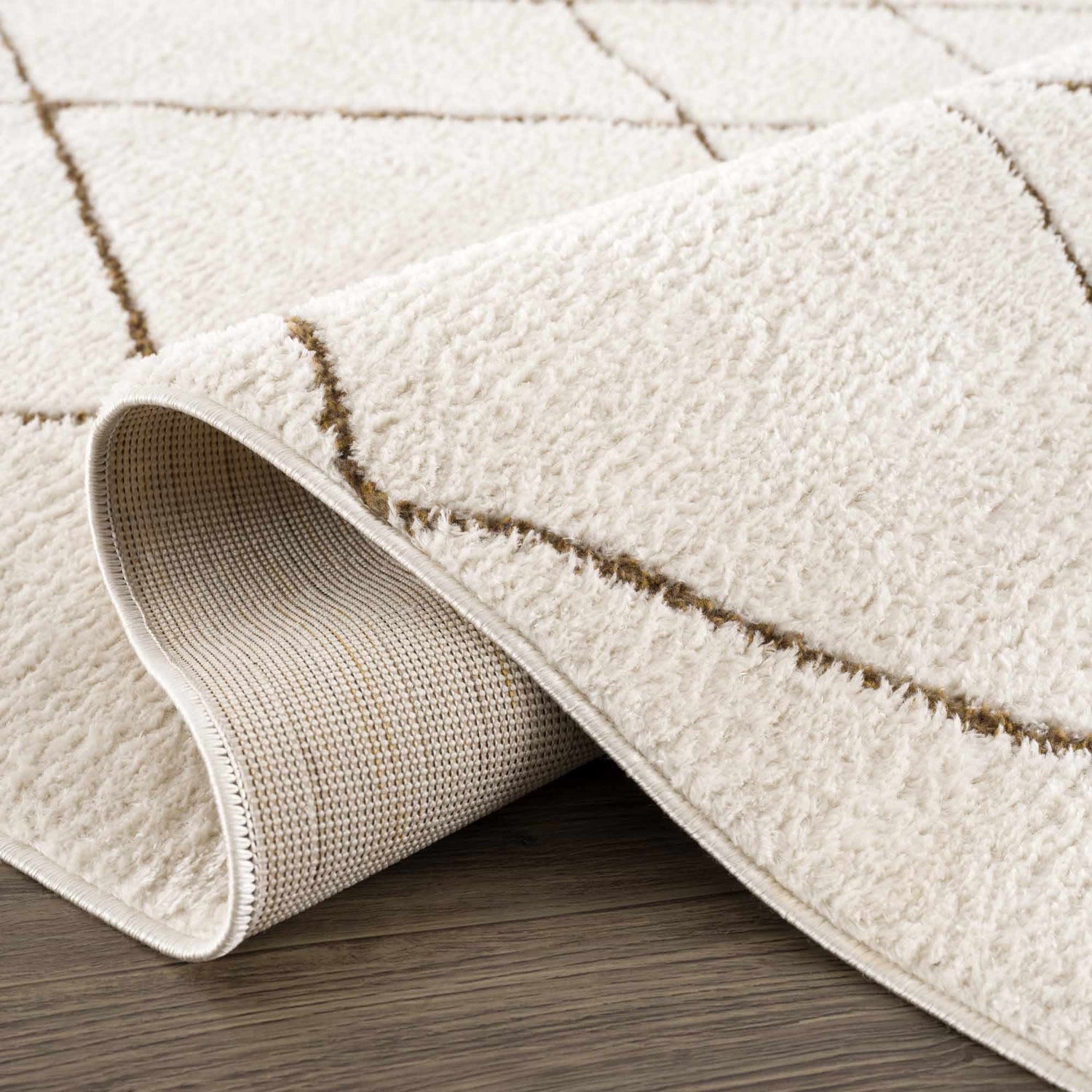 Close up of the ivory Keone Area Rug showing its plush texture and brown geometric diamond pattern. Fold