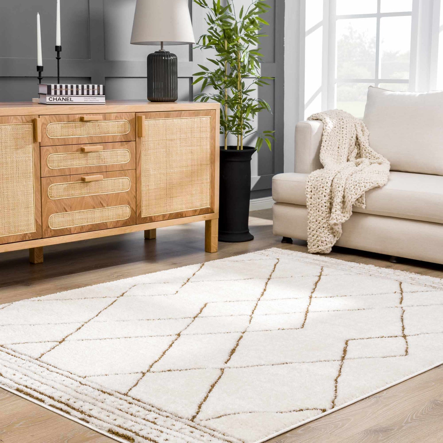 Living room scene with a beige Keone Area Rug, light wood cabinet, and cream sofa. Roomscene-Rectangle