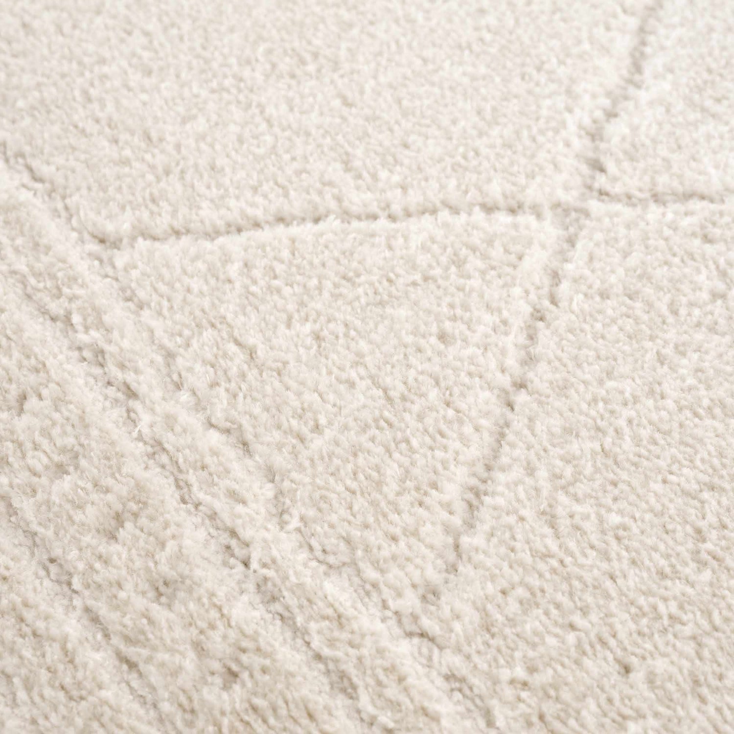 Close-up of the ivory Keone rug, showing its plush texture and subtle geometric pattern. Texture