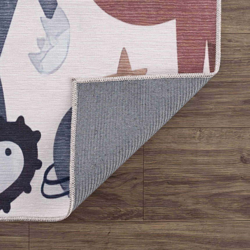 Close-up of the Libra Rainbow Kids Washable Area Rug showing the beige, red, and blue animal pattern and the rug's backing. Fold